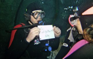 A man proposing to a woman underwater at the Denver Downtown Aquarium