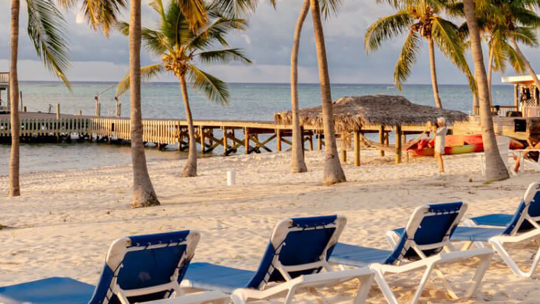 Beach chairs facing the ocean and dock at Little Cayman Beach Resort